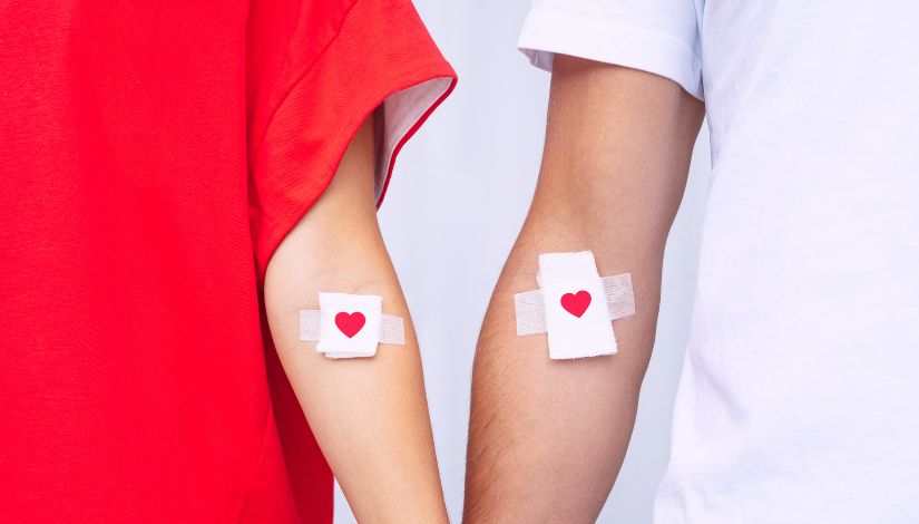 Duas pessoas com curativo no braço após doação de sangue