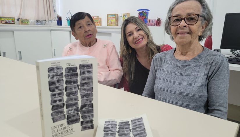 Fotografia de três mulheres sentadas e sorrindo. 