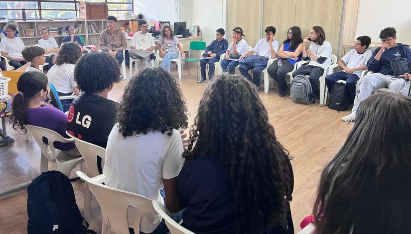Fotografia de estudantes em uma grande roda de conversa
