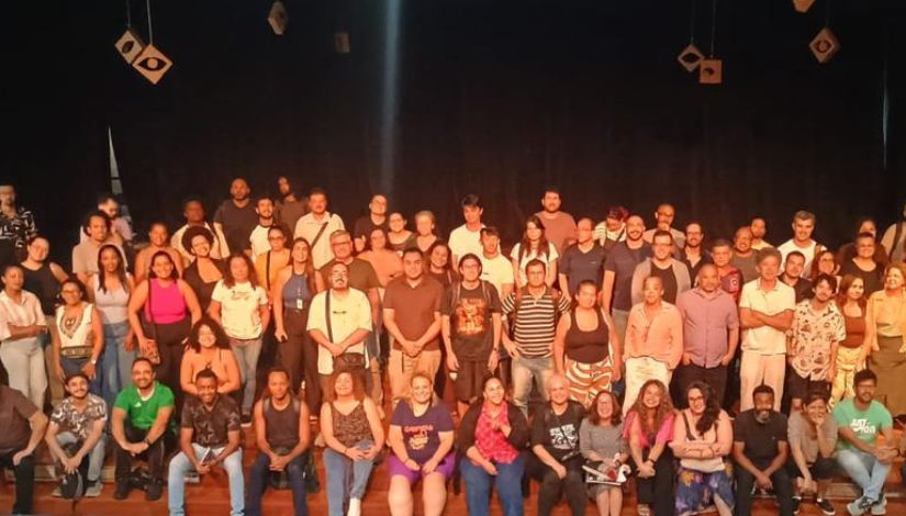 Fotografia de um grande grupo de pessoas no palco posando para a câmera.