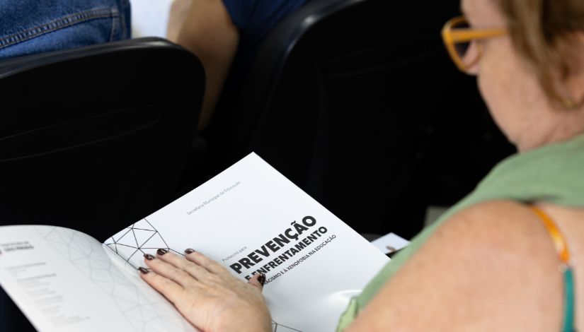 Fotografia de uma mão folheando um livro.