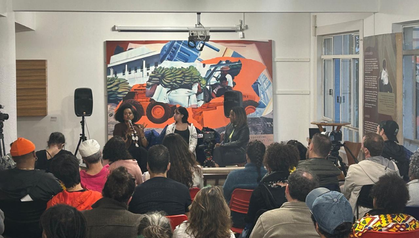 Pessoas conversando em um palco com uma plateira