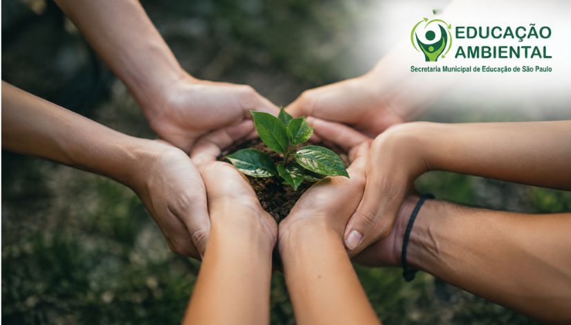 Fotografia ilustrativa mostra mãos de diferentes pessoas unidas ao redor de uma muda de planta com folhas verdes, sustentada sobre um pequeno montículo de terra. A cena simboliza cooperação, cuidado com o meio ambiente e desenvolvimento sustentável. Ao fundo, a vegetação aparece desfocada, reforçando o contexto natural. No canto superior direito, está a identidade visual da Educação Ambiental da Secretaria Municipal de Educação de São Paulo, com logotipo em tons de verde composto por uma figura humana estilizada envolvida por setas circulares, acompanhada da inscrição Educação Ambiental – Secretaria Municipal de Educação de São Paulo.