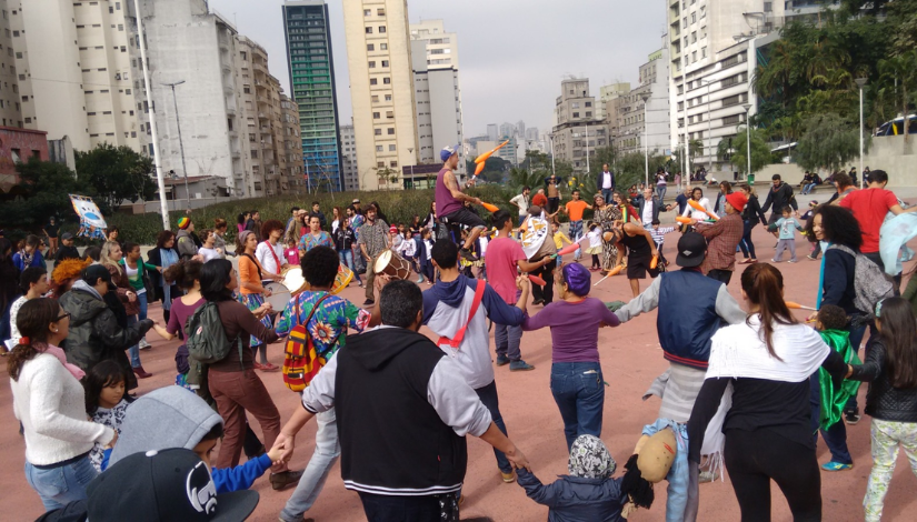Grupo de crianças com famílias celebrando no centro de São Paulo