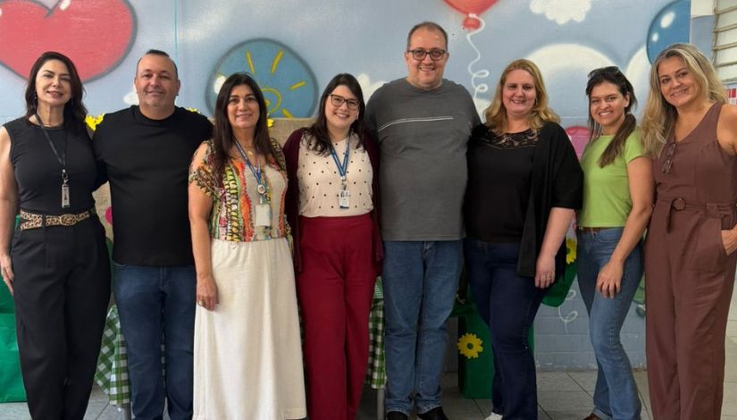 Fotografia de oito adultos em pé posando para câmera.